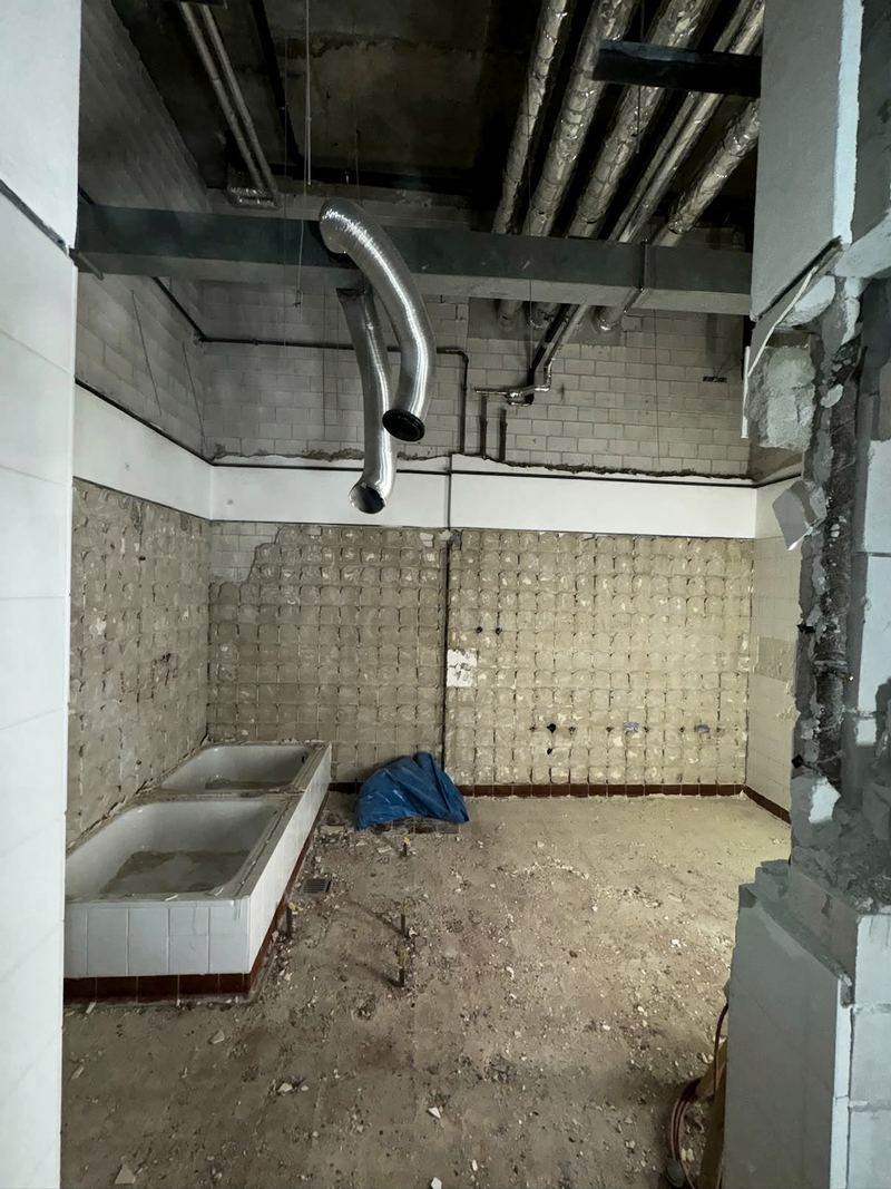 Sanitärraum mit entfernten Fliesen und offener Haustechnik